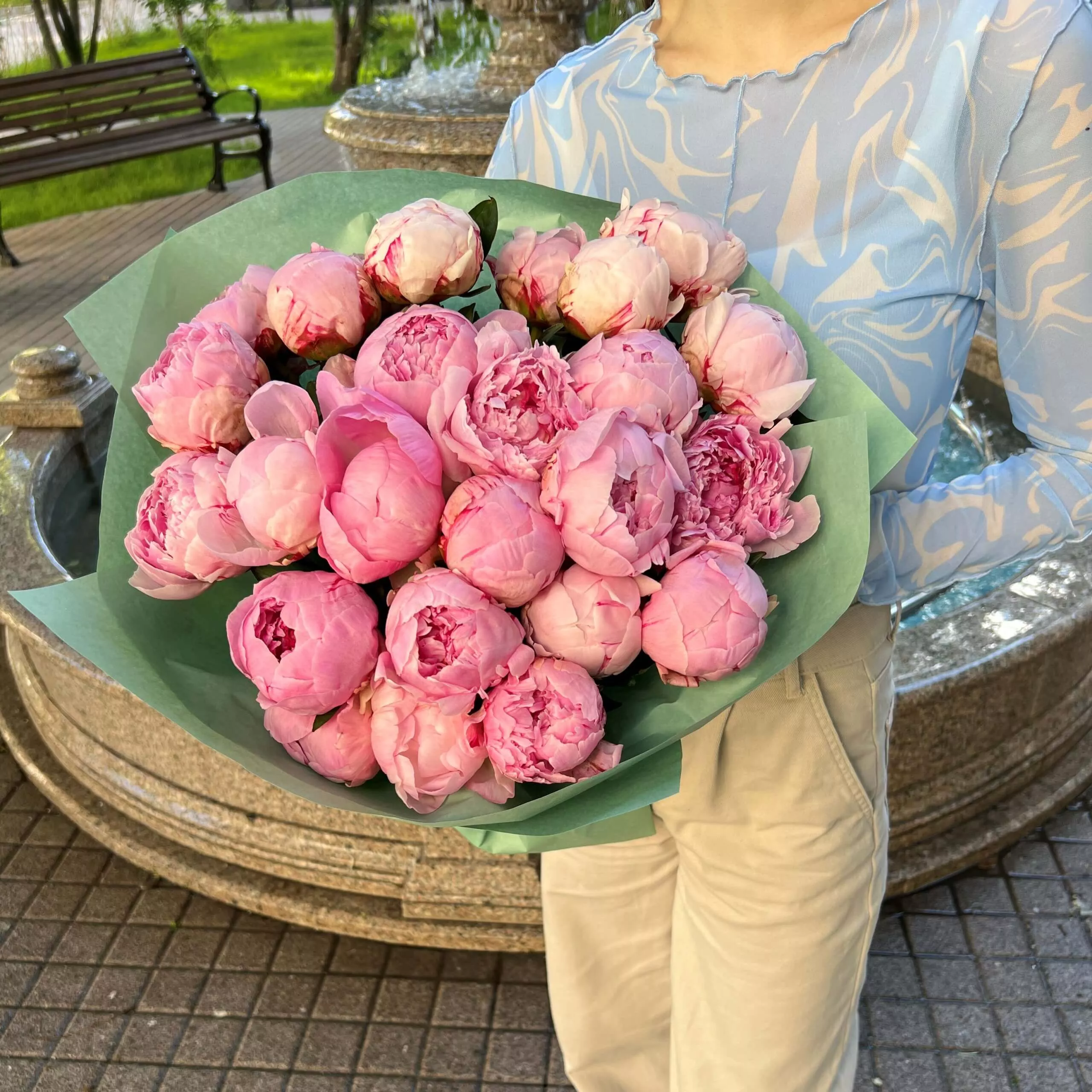 Букет из 25 нежных розовых пионов в зеленом оформлении